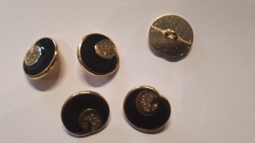 Goudkleurige metalen damesknoop. Zwart met goud.  Doorsnee 18 mm.