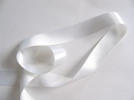 Wit satijnlint per rol van 25 meter. Een hele mooie kwaliteit dubbelzijdig satijnlint.  25 mm breed  100 % polyester