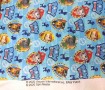 Een lichtblauw/witte poplin/katoenen breedtestreep met Paw Patrol Dog gezichtjes op schildjes 100% katoen 1.50 mtr. br 120 Gr/M2