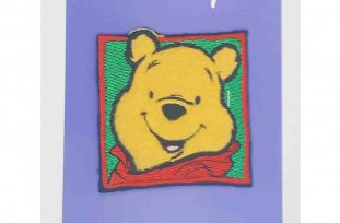 Een Winnie the Pooh applicatie,  met een afmeting van  6 x 6 cm.   Opstrijkbaar. Winnie als pasfoto. 