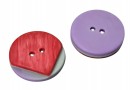 Een rood/groen/paarse kunststof knoop  Doorsnee ongeveer 17,5 mm  Met 2 gaten