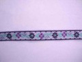 Lila sierband met paarse bloemen.  Ongeveer 12 mm breed  Een stuk van 8 meter en een stuk van 4.5 meter op voorraad