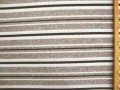 Een gebreide soepelvallende tricot met taupe/grijze breedtestreep. Voelt aan als katoen.  100% polyester  1.40 mtr.br.