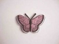 Een opstrijkbare vlinder applicatie van 5 x 3.5 cm. Roze glitter