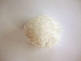 Een wit pom pom bolletje met een doorsnee van 7 cm.  Leuk voor het garneren van mutsen capes of kleding.