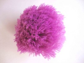 Een paars kleurig pom pom bolletje met een doorsnee van 7 cm.  Leuk voor het garneren van mutsen capes of kleding.