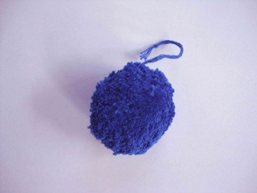 Een kobalt kleurig pom pom bolletje met een doorsnee van 4 cm. en een bevestigings draadje.  Leuk voor het garneren van mutsen c