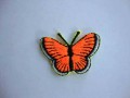 Een opstrijkbare vlinder applicatie van 3 x 2.5 cm. Neon oranje