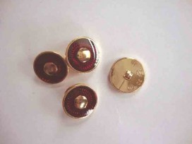 Een kunststof rood/gouden damesknoop met een doorsnee van 18 mm.