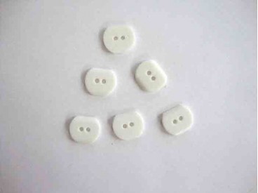 Een witte kunststof knoop met een doorsnee van 22 x 18 mm. 