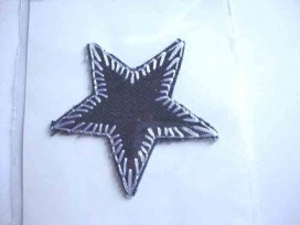 Een opstrijkbare ster applicatie met een doorsnee van 7 cm.