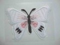 Een witte vlinder applicatie van 7 x 6 cm.  Om te plakken of te strijken, 2 in 1.