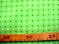 Een lime kleurige bedrukte quiltkatoen met een wit/donker lime mini patroontje. 100% katoen 1.45 mtr.br.